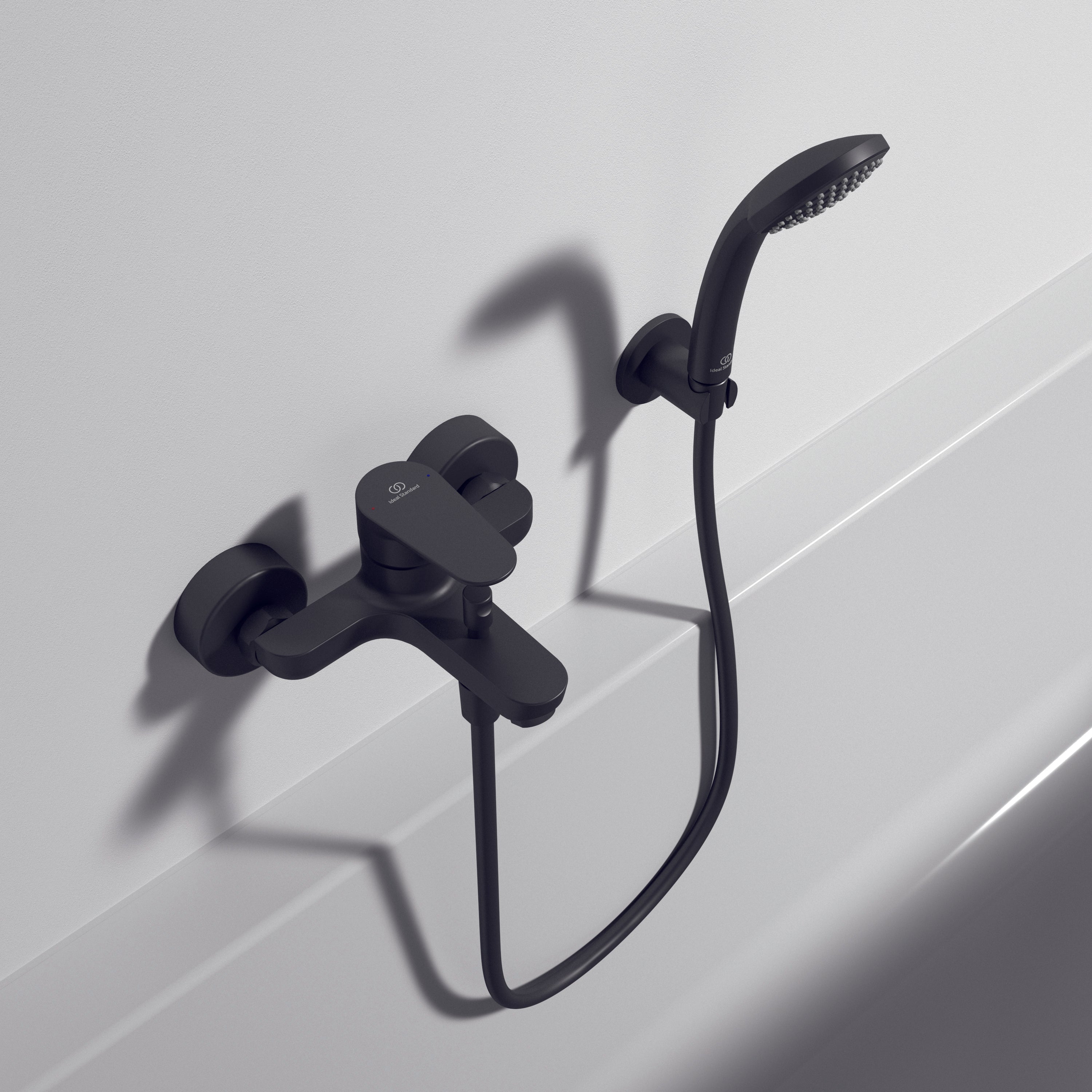 Black shower faucet set on a white tiled wall